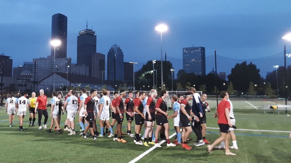 The Maddogs and URI lined up under the lights at Carter Playground with the Boston skyline behind