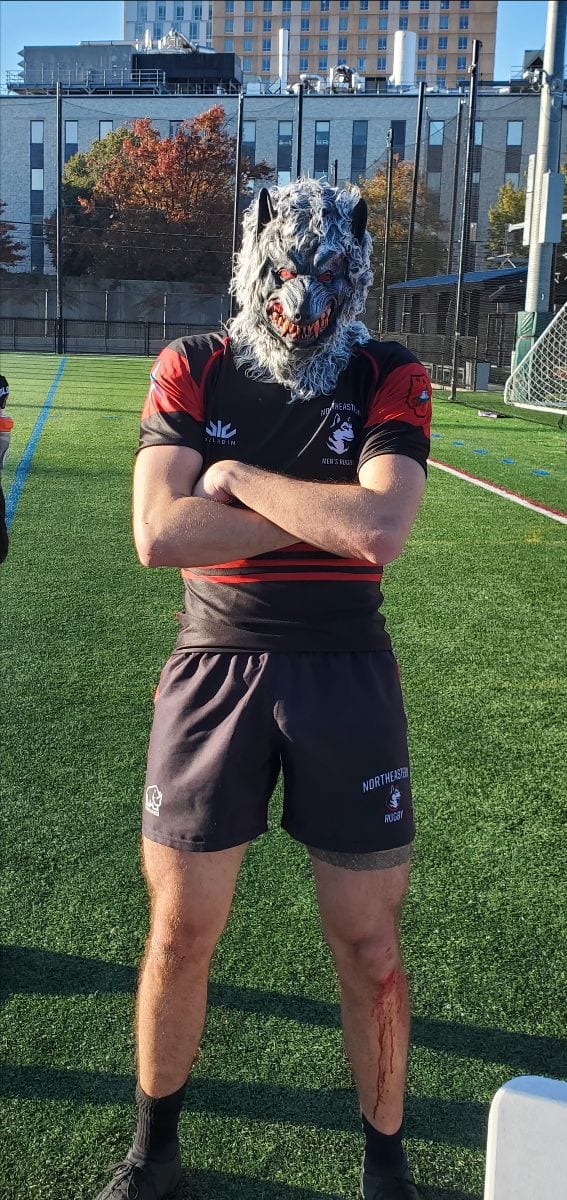 A Maddogs player in a dog mask, arms folded, on the pitch