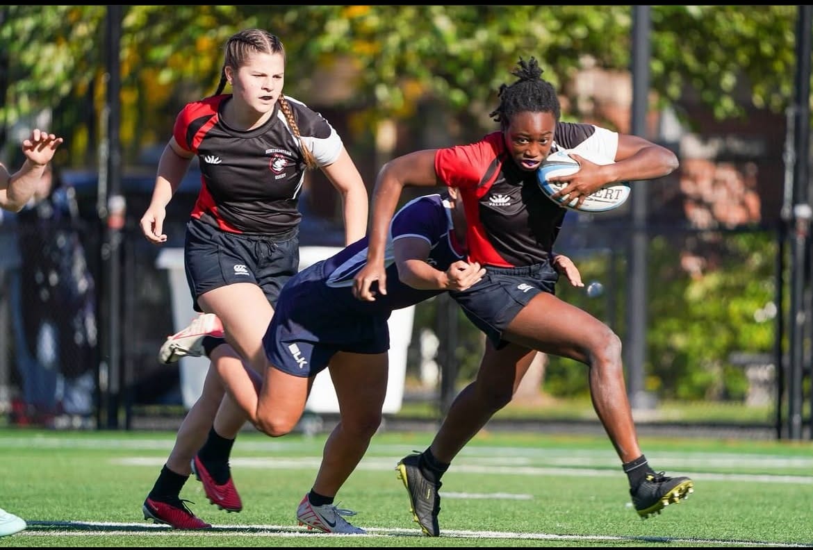 A Northeastern women's player carries into contact